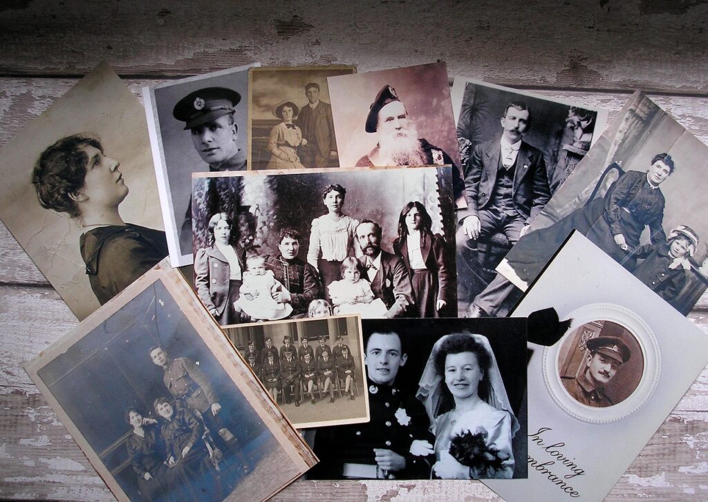 Flat lay of old black-and-white family photographs on a wooden table
