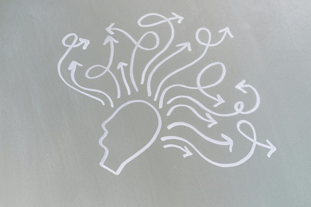 Silhouette of a head with swirling arrows radiating outward, symbolizing nonlinear thinking and mind map brainstorming.
