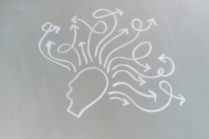 Silhouette of a head with swirling arrows radiating outward, symbolizing nonlinear thinking and mind map brainstorming.