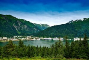 Cruise ships docked in Juneau, Alaska with mountains and forest in the background — first Alaska cruise.