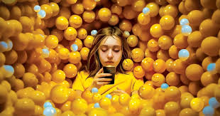 Cover of the book “The Anxious Generation” by Jonathan Haidt featuring a girl in a yellow ball pit looking at a phone