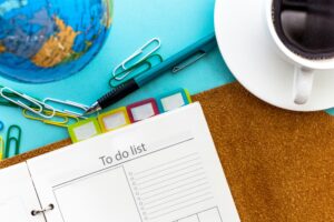 Home Open planner with to-do list, colorful tabs, pen, coffee cup, and globe — illustrating communicating with different learning styles