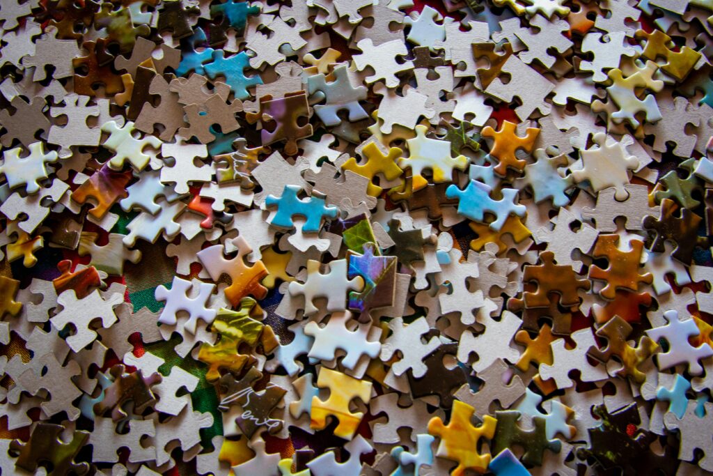 Colorful puzzle pieces scattered on a wooden surface, symbolizing organizing a scattered mind