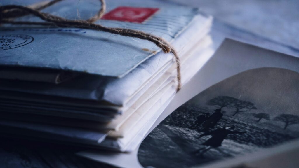 Stack of vintage letters tied with twine beside an old photograph, symbolizing intentional, personal communication and the art of rethinking newsletters.