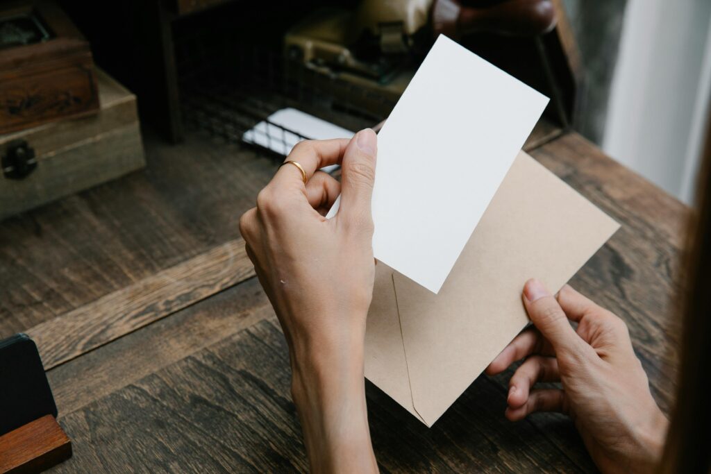 Hands holding an open envelope with a blank invitation card, symbolizing thoughtful planning and human connection.