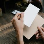 Hands holding an open envelope with a blank invitation card, symbolizing thoughtful planning and human connection.